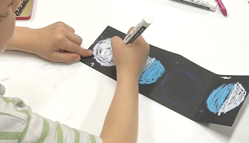 Atelier calendrier lunaire - Photo d'un enfant en réalisant un bleu et blanc