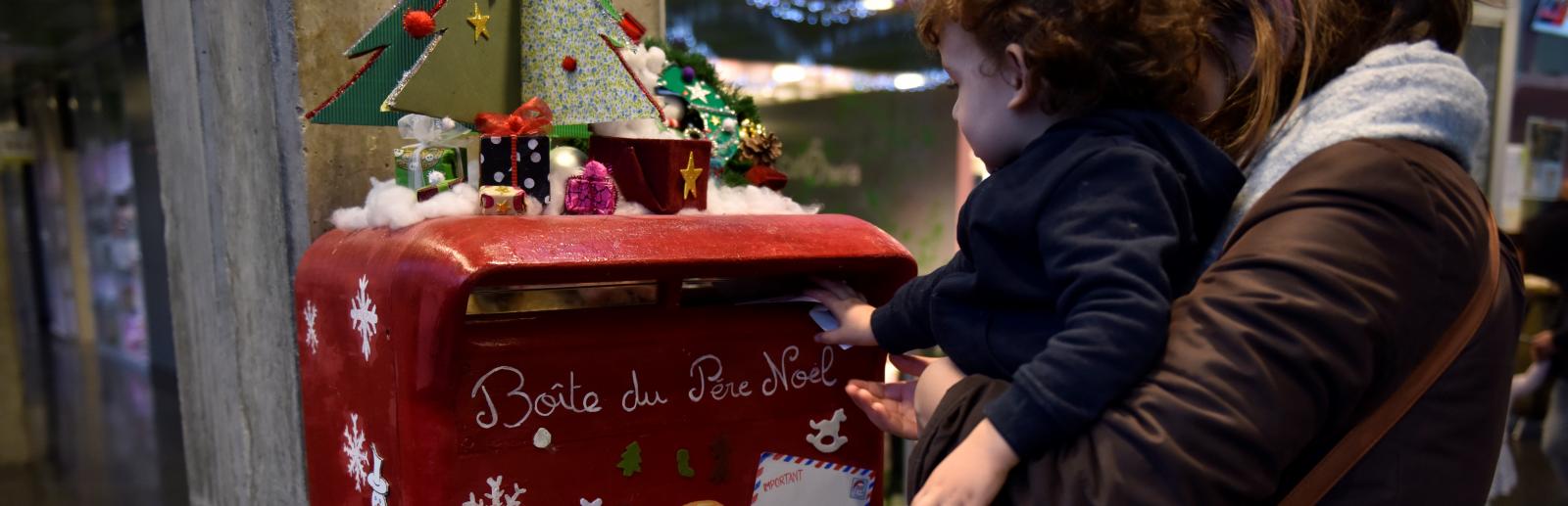 Atelier de noël à l’hôpital Necker, un enfant et sa mère déposant une lettre dans la boite aux lettres décorés Atelier de noël à l’hôpital Necker, un enfant et sa mère déposant une lettre dans la boite aux lettres décorés